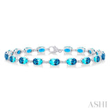 6X4 MM Oval Cut Blue Topaz and 1/6 Ctw Round Cut Diamond Semi-Precious Tennis Bracelet in 10K White Gold